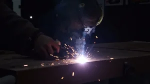This image shows a welding machine with a visible arc, illustrating potential issues for fixing weak arc in MIG welding.