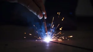 The image shows a Mig welder's wire feeder mechanism, illustrating how to prevent wire feed jams in Mig welders.