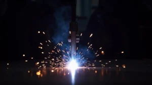 The image shows a MIG welder's nozzle with minimal spatter, demonstrating efficient techniques to reduce spatter.