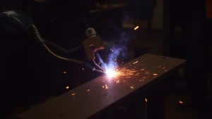 The image shows a TIG welding torch producing an unstable arc, illustrating a troubleshooting problem.