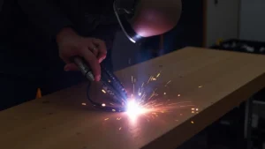 The image shows a TIG welder's torch held near a workpiece, illustrating a weak arc troubleshooting scenario.