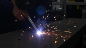 The image shows a welding machine, likely related to troubleshooting its clicking noise issue and steps to fix it.